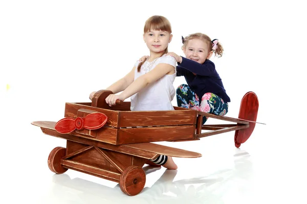 Duas irmãs brincando em um avião de madeira — Fotografia de Stock