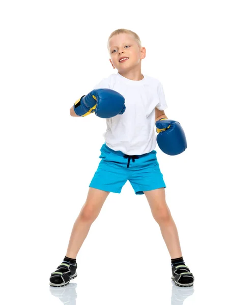 Um menino em uma camiseta branca limpa e luvas de boxe . — Fotografia de Stock