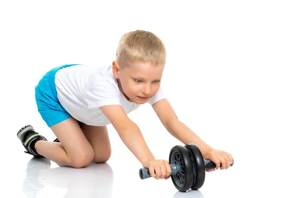 Un bambino in una t-shirt bianca pulita è impegnato in fitness. — Foto Stock