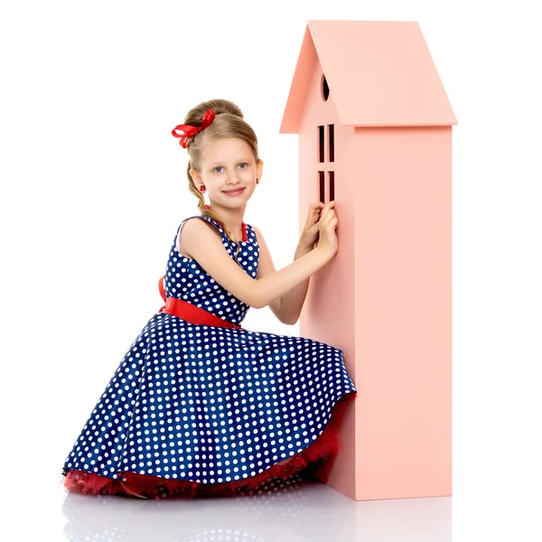 Little girl is playing with wooden houses. — Stock Photo, Image