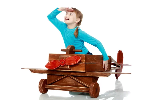 Das Mädchen spielt mit einem großen Spielzeugflugzeug. — Stockfoto