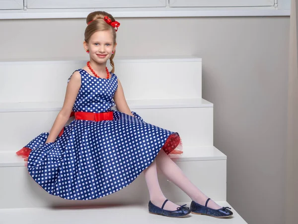 A little girl is standing on a white staircase. — Stock Photo, Image