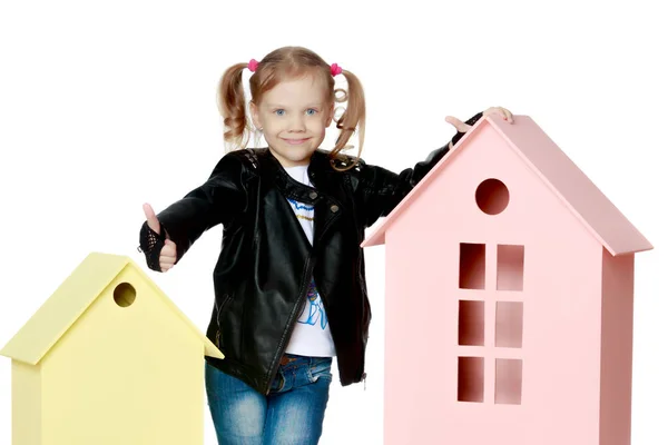 Malá dívka hraje s dřevěnými domy. — Stock fotografie