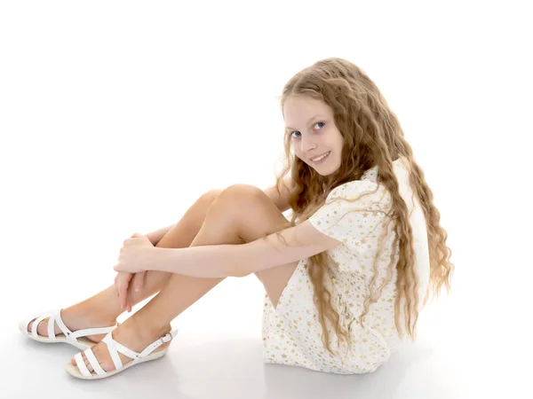 En tonårig flicka sitter på golvet. — Stockfoto