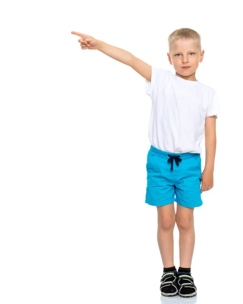 Een jongetje in een zuivere witte T-shirt is wijzend op iets. — Stockfoto