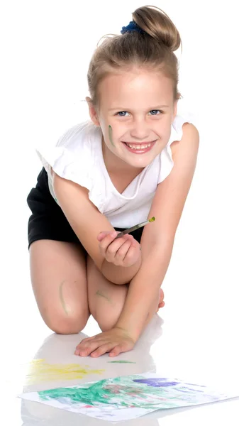 Ein kleines Mädchen malt mit Farbe und Pinsel. — Stockfoto