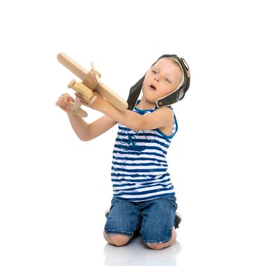 Little boy playing with wooden plane clipart