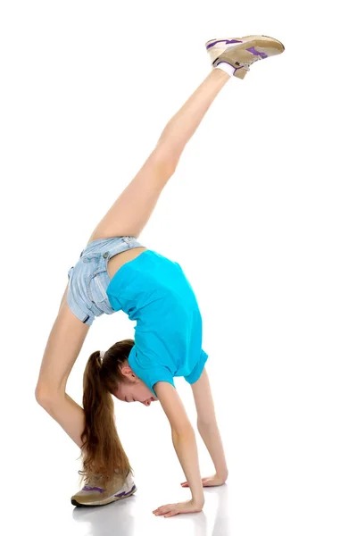 The gymnast performs a bridge with a raised leg. — Stock Photo, Image