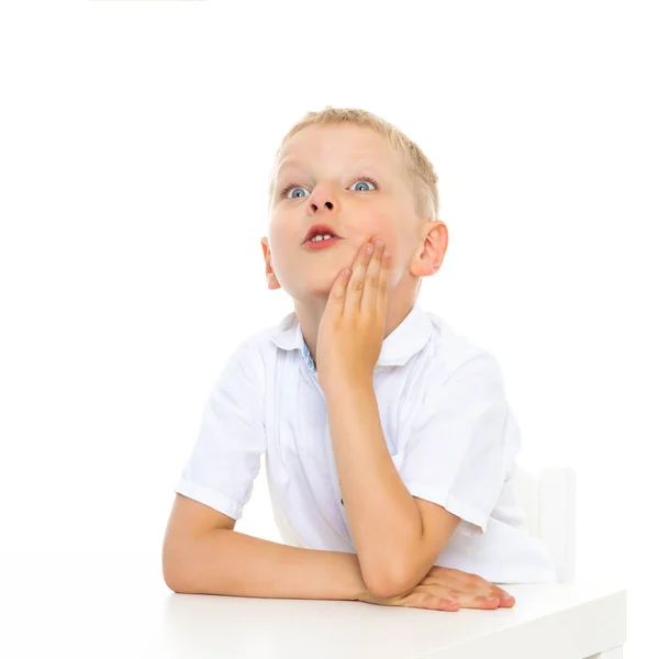 Ein Süßer Kleiner Junge Sitzt Der Schule Einem Schreibtisch Und — Stockfoto