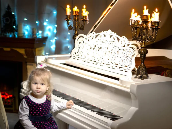 Bambina suona il pianoforte a lume di candela. — Foto Stock