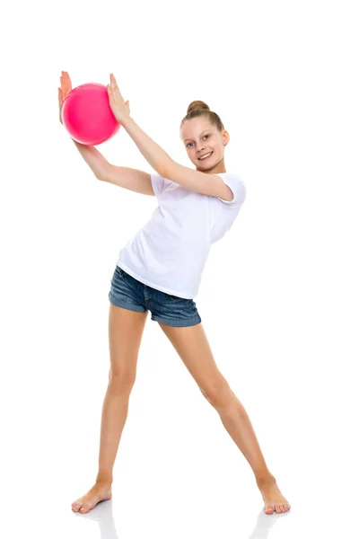 Dziewczyna gimnastyczka wykonuje ćwiczenia z piłką. — Zdjęcie stockowe