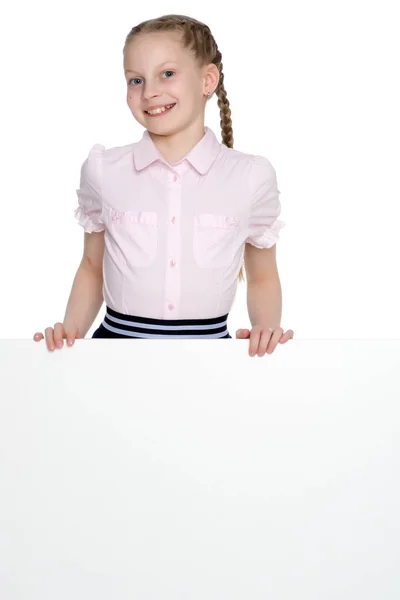 A little girl is looking from behind an empty banner. — Stock Photo, Image