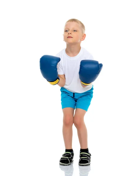 Een jongetje in een schone witte T-shirt en bokshandschoenen. — Stockfoto