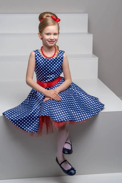 A little girl is standing on a white staircase. — Stock Photo, Image