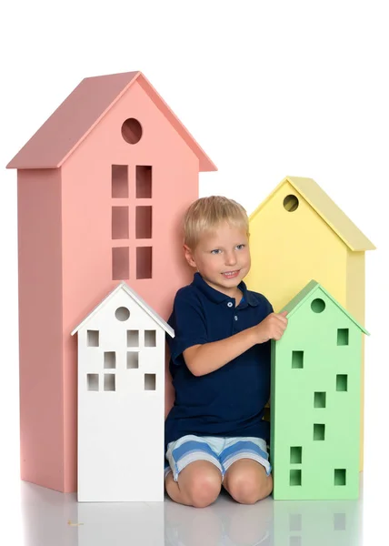एक छोटा लड़का रंगीन घरों के साथ खेल रहा है . — स्टॉक फ़ोटो, इमेज