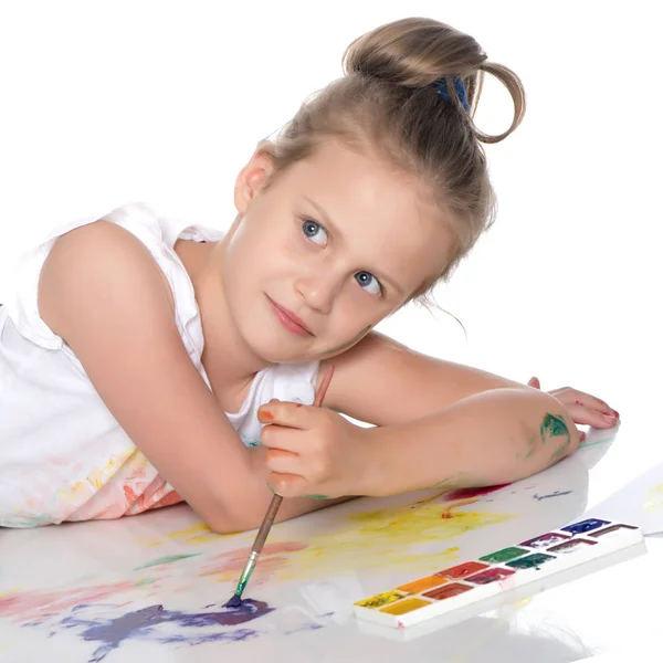 Une petite fille peint avec de la peinture et un pinceau . — Photo