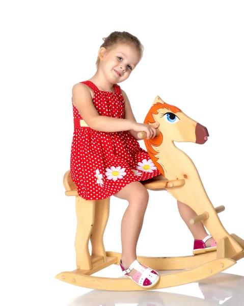 Flicka gungar på en trähäst. — Stockfoto