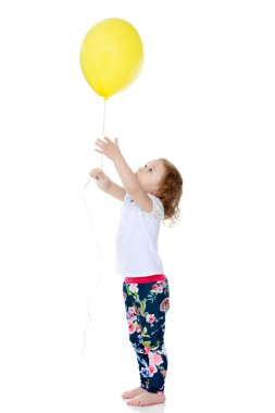 Küçük kız bir balonla oynuyor.