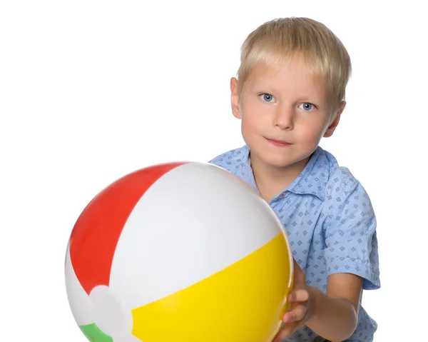 Um menino está brincando com uma bola . — Fotografia de Stock