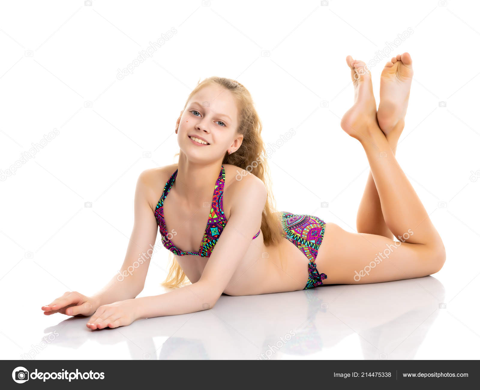 A little girl in a bathing suit lies. Stock Photo by lotosfoto1