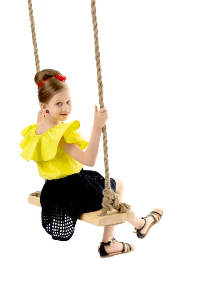 Joyeuse petite fille balançant sur une balançoire. — Photo