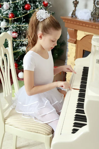 Flickan pressar stämm av pianot. — Stockfoto