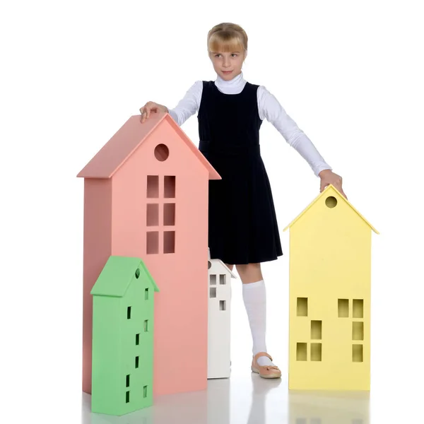 Little girl is playing with wooden houses. — Stock Photo, Image