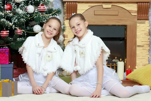 Дівчата близнюки з подарунками е Різдвяна ялинка . — стокове фото