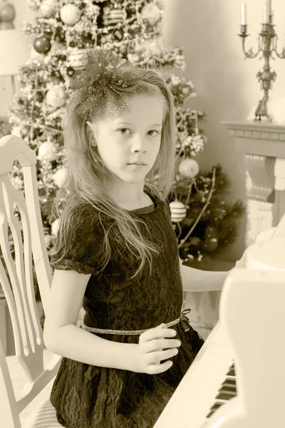 A kislány egy fehér zongora. — Stock Fotó
