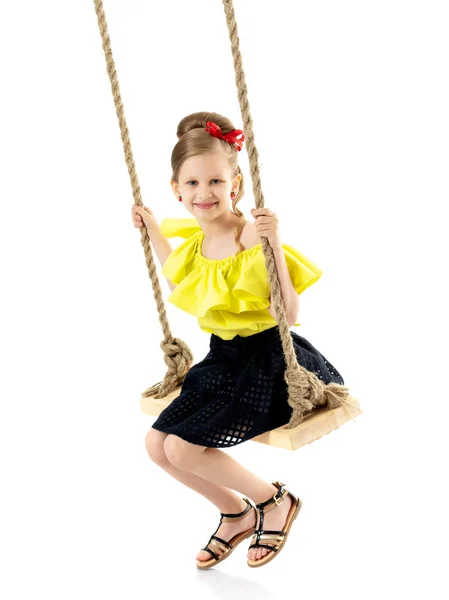 Glada lilla flickan gungar på en gunga. — Stockfoto