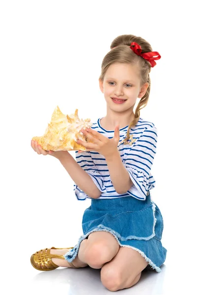 Маленькая девочка с морской раковиной — стоковое фото