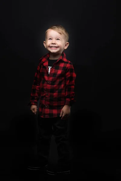 Kleine jongen op een zwarte achtergrond. — Stockfoto