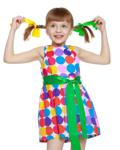 Una niña en un vestido con un patrón de circl multicolor — Foto de Stock