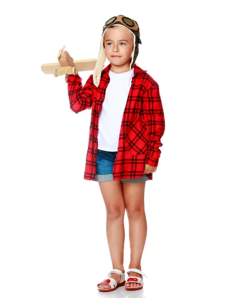 Niña con un avión de madera en la mano. — Foto de Stock