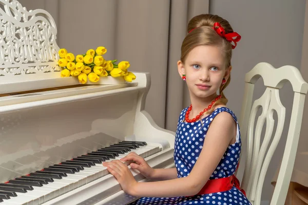 Flicka Skolflicka nära piano som ligger en bukett av blomma — Stockfoto