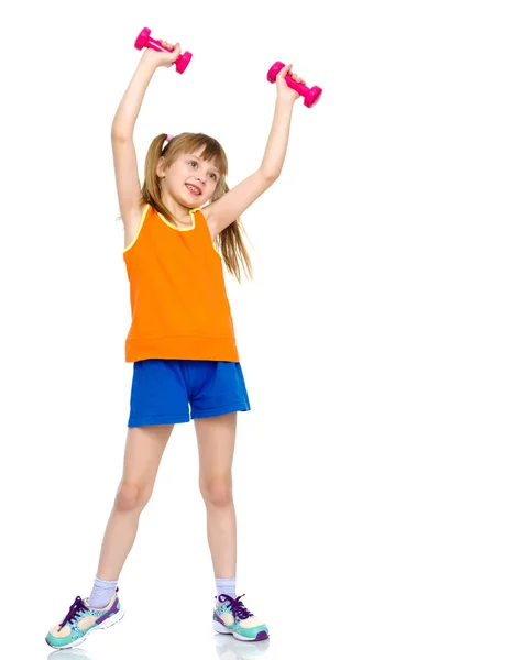 Little girl doing exercises with dumbbells. — Stock Photo, Image