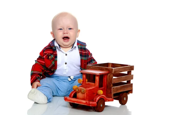 A little boy is playing with a toy car. — Stock Photo, Image