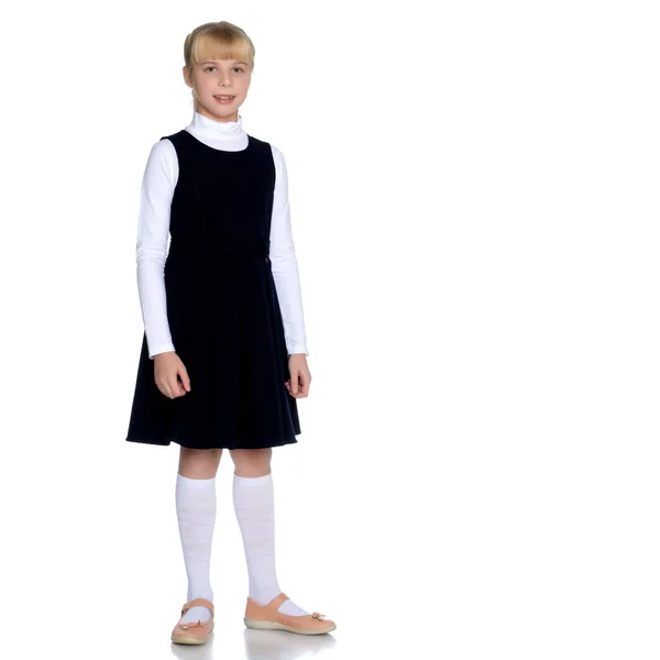 Vacker liten flicka i en skoluniform. — Stockfoto