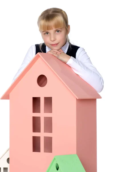 Little girl is playing with wooden houses. — Stock Photo, Image