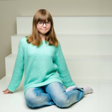 Lale bir buket ile küçük bir kız merdivende oturuyor.