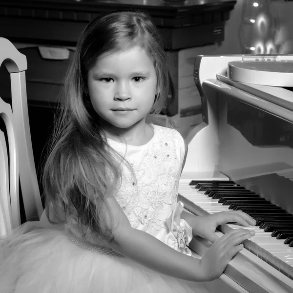 Bambina suona il pianoforte a lume di candela. — Foto Stock