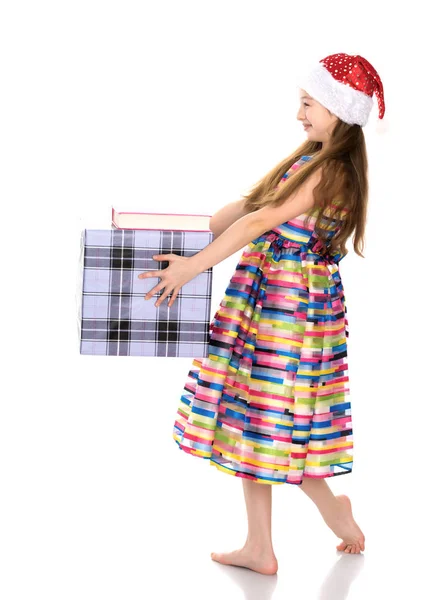 Una bambina con un regalo in un cappello di Babbo Natale . — Foto Stock