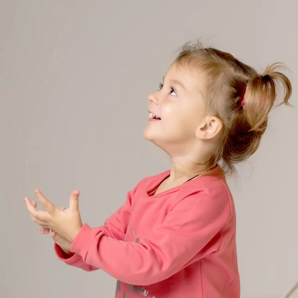 Uma menina feliz está acenando a mão. — Fotografia de Stock