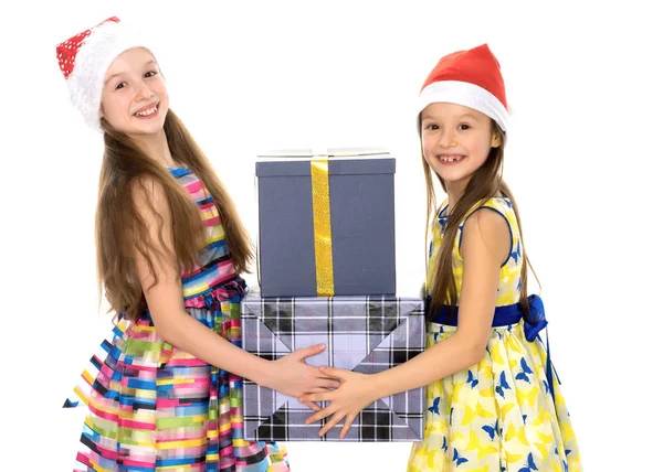 Les filles sont des sœurs dans le Père Noël chapeaux et cadeaux . — Photo