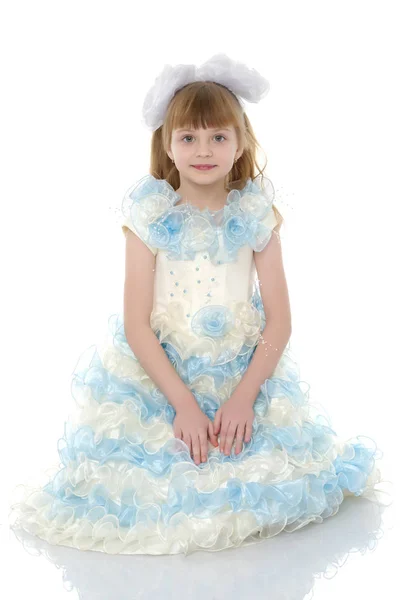 Menina de vestido branco posando como uma princesinha