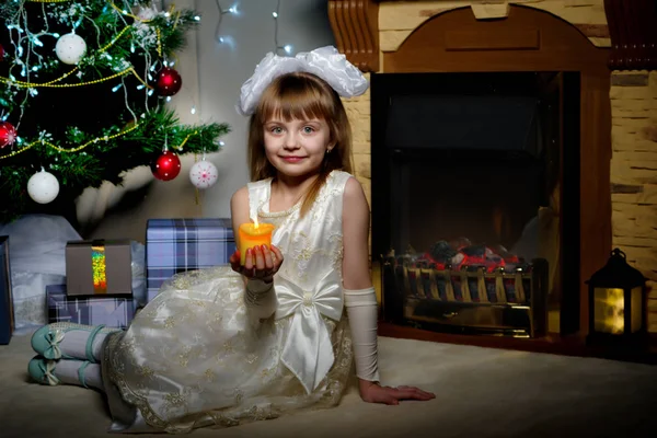 Una niña en una habitación oscura a la luz de las velas. —  Fotos de Stock