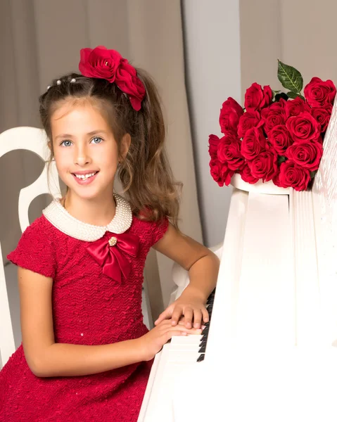 Flicka Skolflicka nära piano som ligger en bukett av blomma — Stockfoto