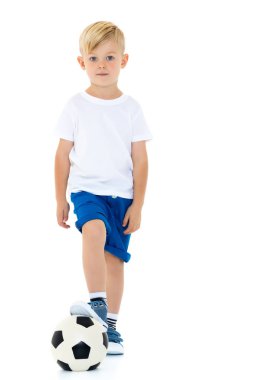 Küçük çocuk bir futbol topuyla oynuyor.