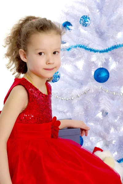 Petite fille avec un cadeau au sapin de Noël. — Photo