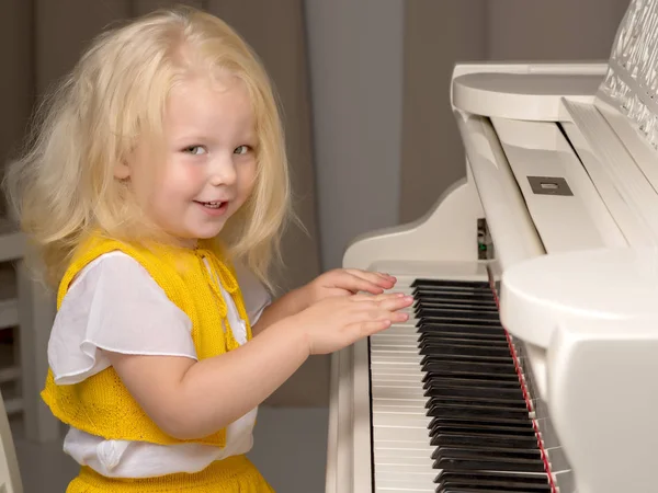 美しい少女は白いグランドピアノで遊んでいます. — ストック写真
